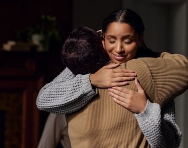 a woman in a sweater is hugging her friend