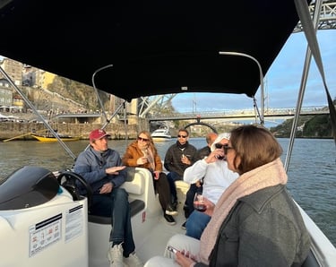 Guests chatting with Captain Francisco on Endure, with Porto’s Dom Luís I Bridge in the background