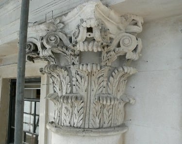 a column with a floral portland stone decorating arrangement on the outside