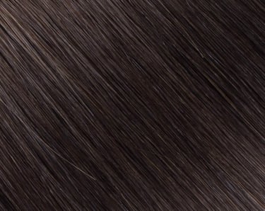 Gros plan de la texture de rallonges de cheveux brun espresso foncé, lisses et brillants.