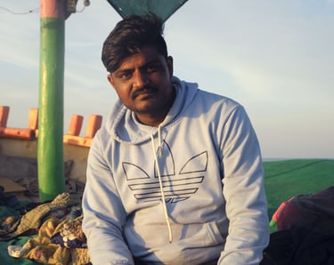 a man sitting on a blanket in a tent