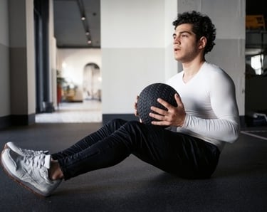 a young man holding a medicine ball