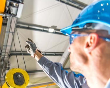 crane inspector looking at overhead crane hook and rope