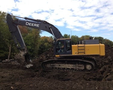 John Deere Excavator digging up dirt