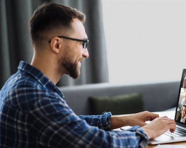 A man sitting at a table with a laptop computer