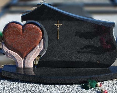 juodos spalvos kareliško akmens paminklas su rudo akmens širdimi