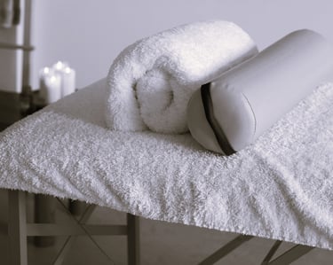 Une table de massage avec des coussins.