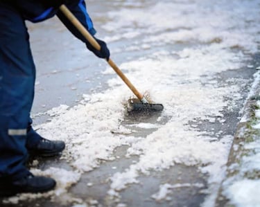 a house with a driveway that is having the ice scraped away