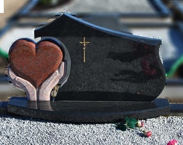 juodos spalvos kareliško akmens paminklas su rudo akmens širdimi