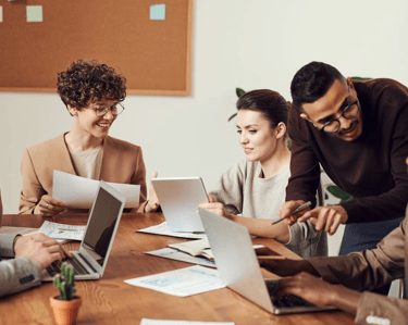 Equipe diversa trocando feedback de forma horizontal e respeitosa