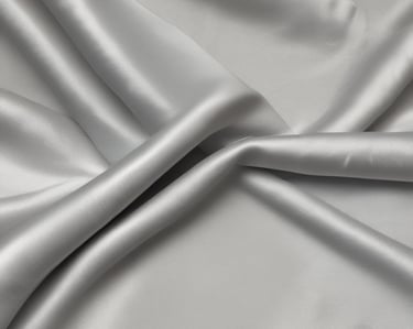 Modern cargo ship loaded with containers set against a clear blue sky at a busy port.