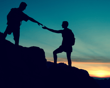 a man and woman holding hands on a mountain