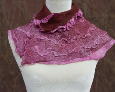 Handmade pink and maroon ruffled nuno felted wool neck warmer displayed on a white mannequin torso.