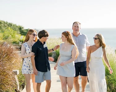 Family walking together beside the ocean cliffs during a family photography session at AYANA Resort Bali