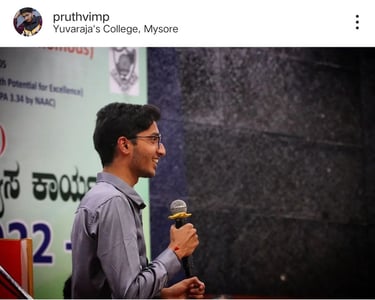Pruthvi M P in a gray shirt and a microphone