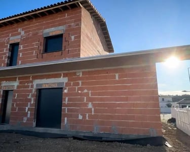 a house with a brick wall and a small house