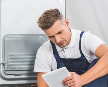 a man in a blue apron and a tablet computer