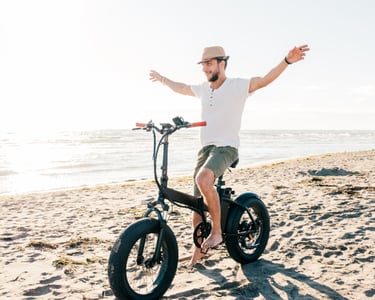 a man riding a bike on a beach