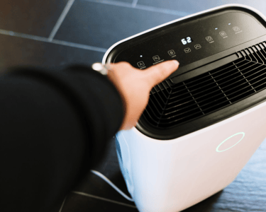 a person holding a small air conditioner