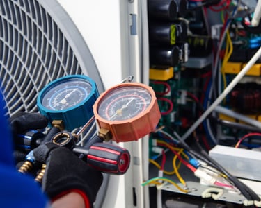 a man in a blue shirt and gloves holding a gauge