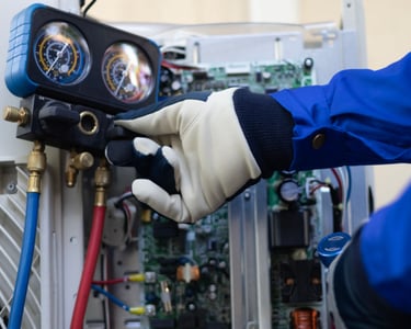 a person in a blue jacket and gloves holding a hose and a hose