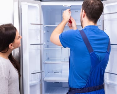 a man and woman standing in front of a refrigerator