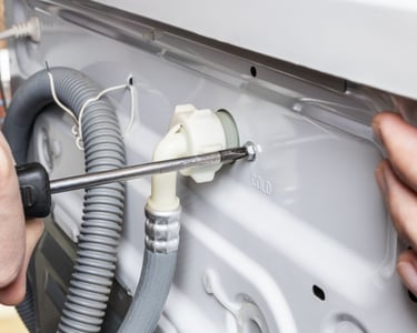 a person is fixing a dishwasher in a kitchen