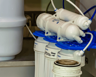 a water filtrator with a blue plastic container