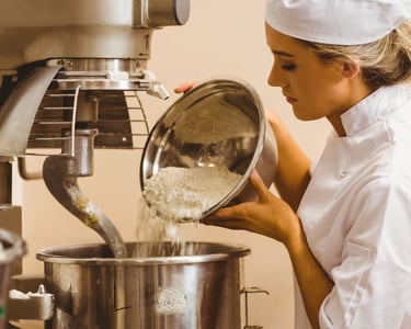 a woman in a chef's hat is pouring flour into a potted pot