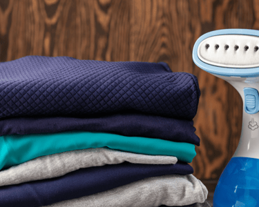 a pile of folded folded towels and a blue and white electric razor razor razor razor