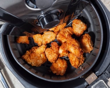 a fryer with chicken nuggling in it