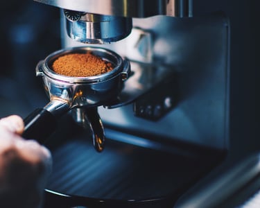 a person is making a coffee in a coffee machine