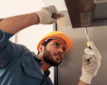 a man in a hard hat and gloves is holding a knife and a knife in