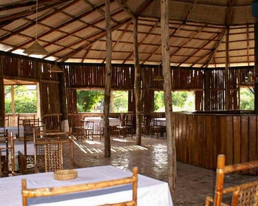 A scenic view of the Sita Joyeh Baobab Island Lodge in Kuloro, featuring rustic wooden cabins nestle