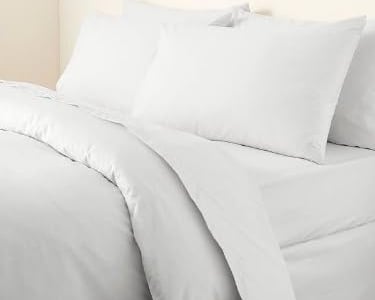 a bed with white sheets and pillows on it