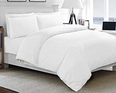 a bed with a laptop on top of it