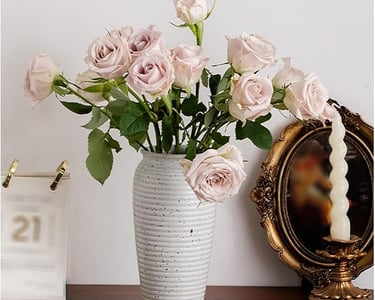 a vase with pink roses in a vase on a table