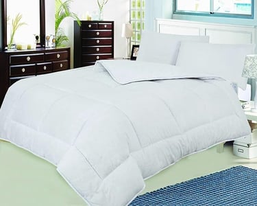 a bed with a white comforter and a blue rug