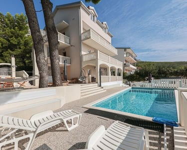 The photo shows a house with a part of the yard with a west sun terrace and a swimming pool.