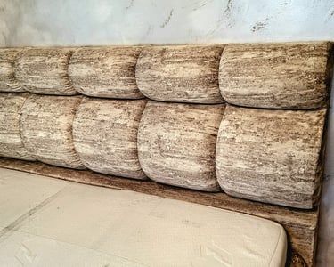 Custom channel tufted upholstered headboard with a textured stone-patterned fabric in a modern bedroom.