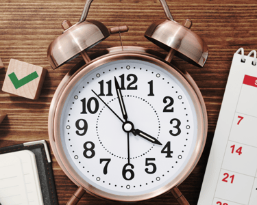 a clock on a desk with a calendar and a calendar