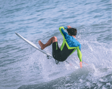 a man in a wetsuit surfing on a surfboard