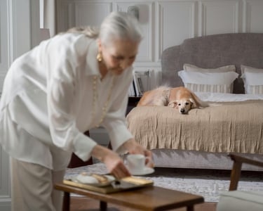 a woman in a white shirt and a dog on a bed