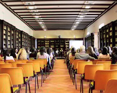 una clase con mucha gente sentada en sillas