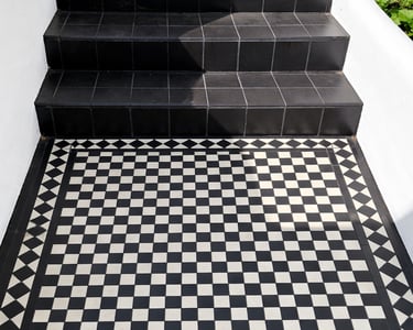 Victorian style black and white checkered floor tiles leading to dark slate garden steps in Brighton