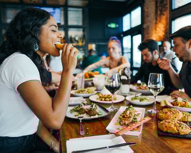 woman enjoying a delicious meal in a fancy restaurant, sharing with friends 