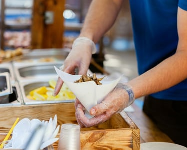 chef serving food on-the-go - kebab style with options - knife and fork in foreground