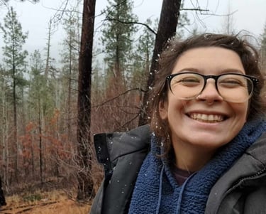 A smiling person in a forest