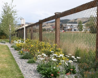 a fenced in area with a fence and flowers