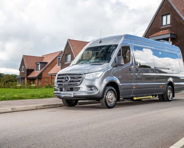 16 seater silver van parked on the side of a road